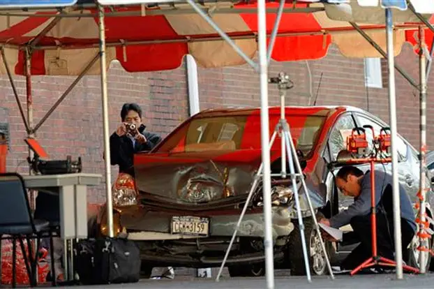 Photograph of NHSA officials photographing the Prius last week by Stephen Chernin/AP